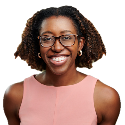 A woman with curly hair, wearing glasses and a sleeveless pink top, smiles at the camera against a plain white background.
